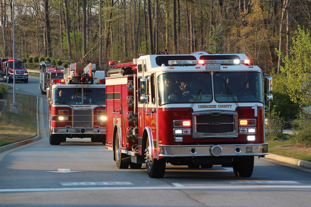 A firefighter waves from the cab of his vehicle as they make their way to Northside Cherokee Hospital. A firefighter waves from the cab of his vehicle as they make their way to Northside Cherokee Hospital.