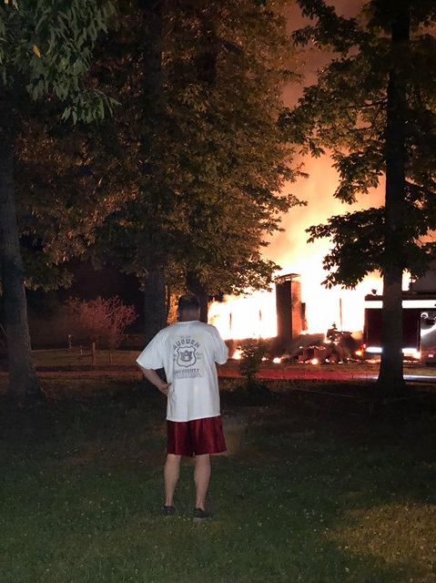 An onlooker watches as the fire burns the house down (photo by Jimmy Kelley).