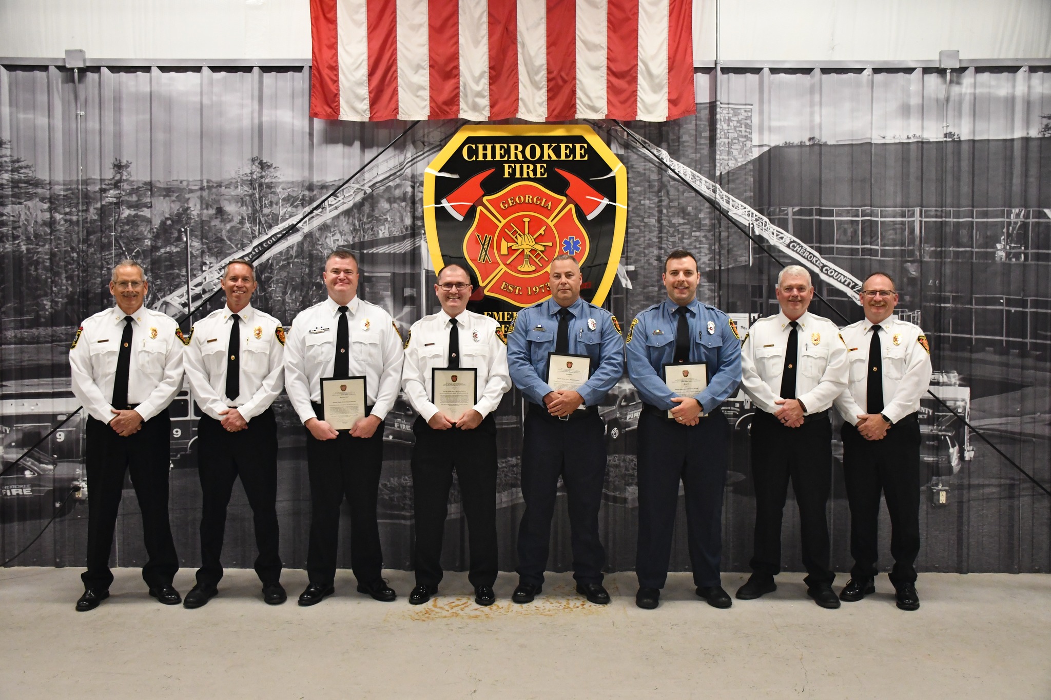 Fire department command staff members stand with the newly promoted members of CCFES.