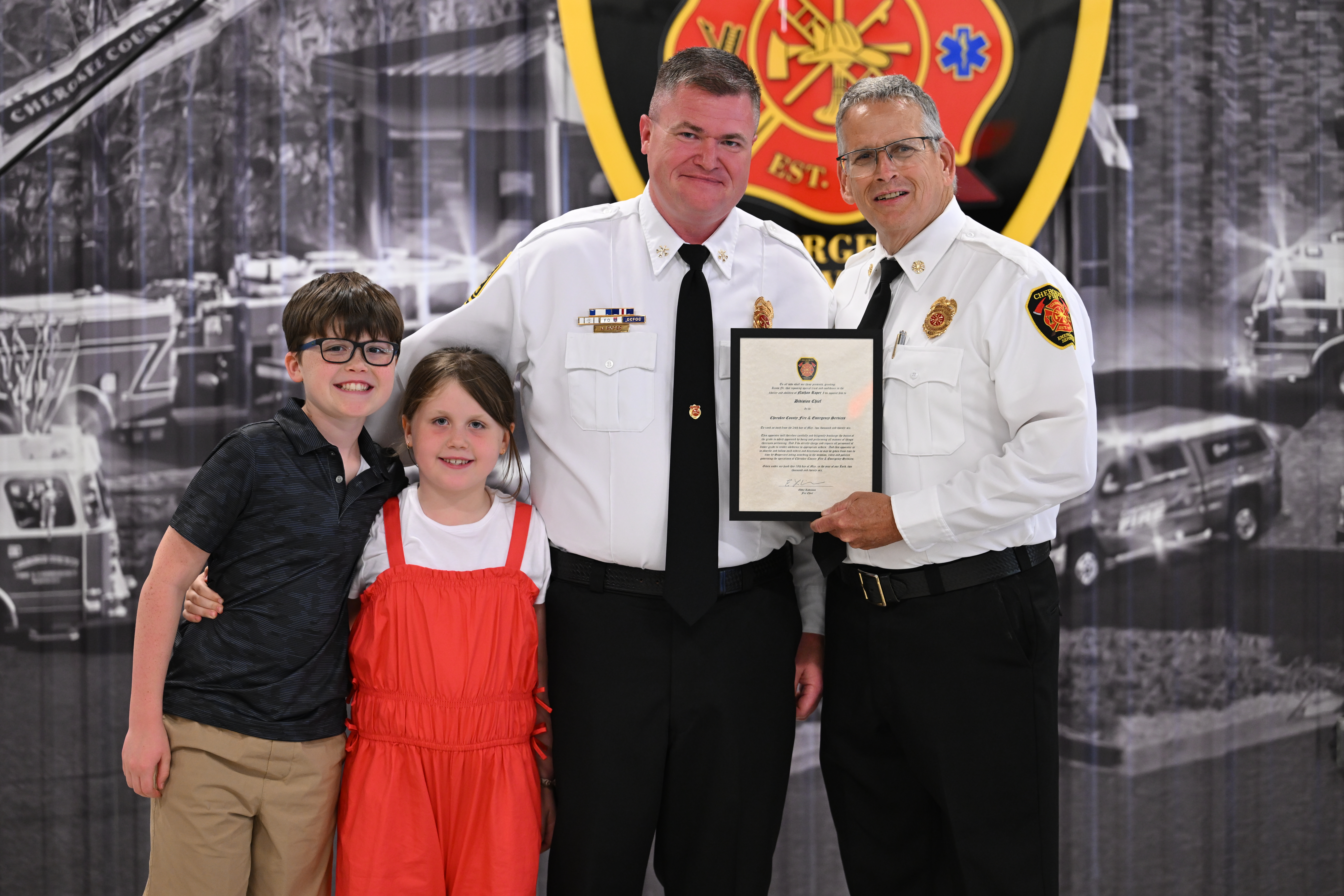 Chief Robinson congratulates Division Chief Nathan Roper and his family. 